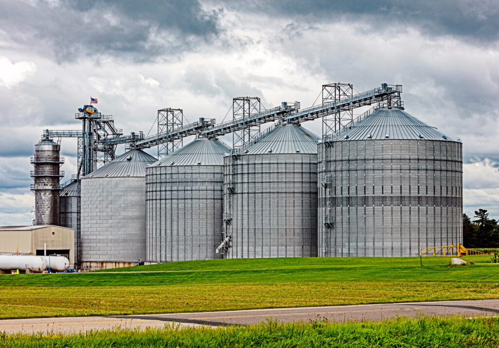 Four propane grain dryers in a field.