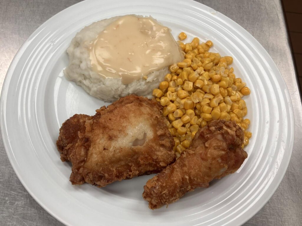 Broasted chicken meal with mashed potatoes, gravy, and corn