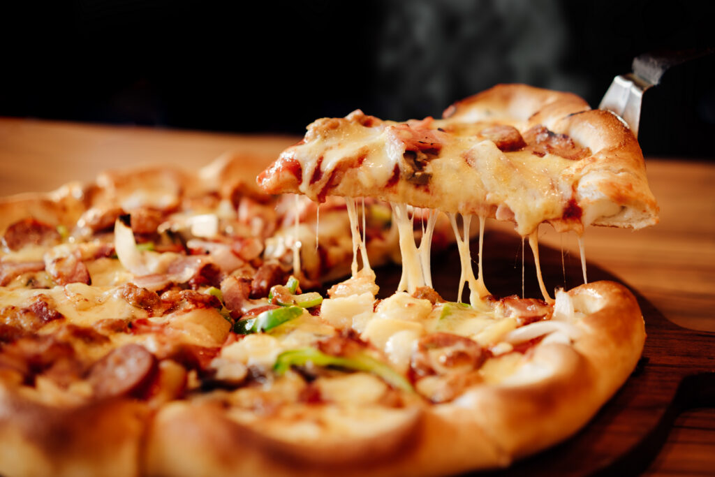 Slice of pizza with bell pepper and meat.